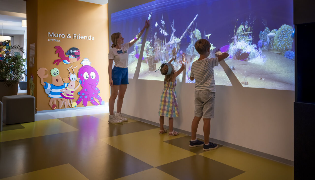 Children explore an interactive underwater projection wall with a Maro & Friends host at Valamar Camping Istra.