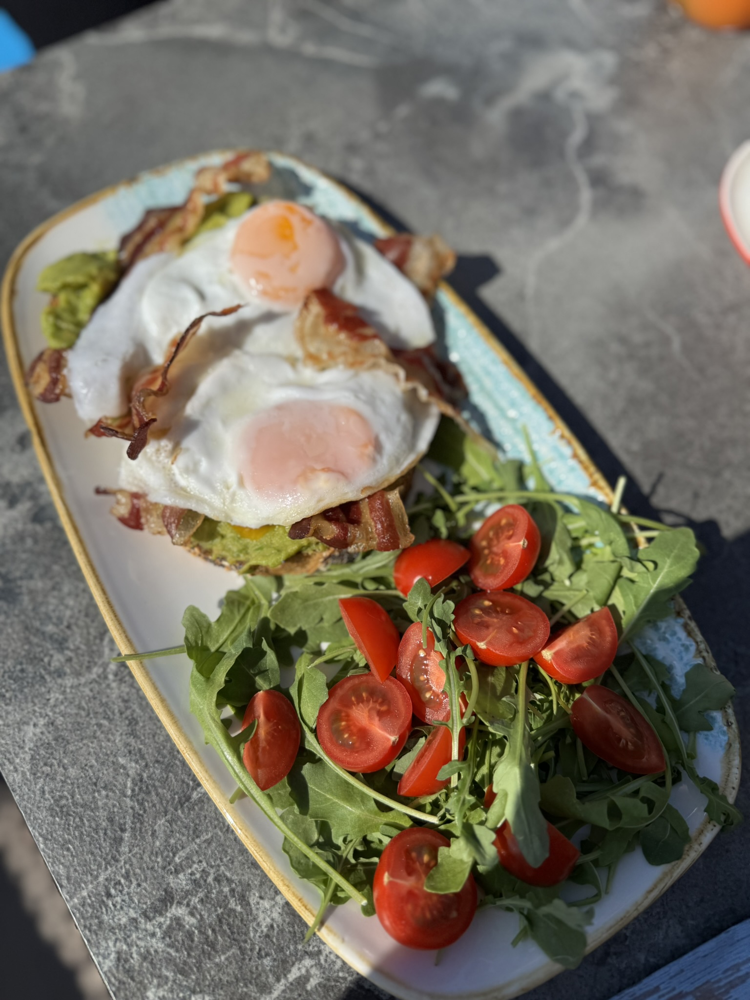 Fried eggs with bacon and a salad of arugula and tomatoes Fried eggs with bacon and a salad of arugula and tomatoes