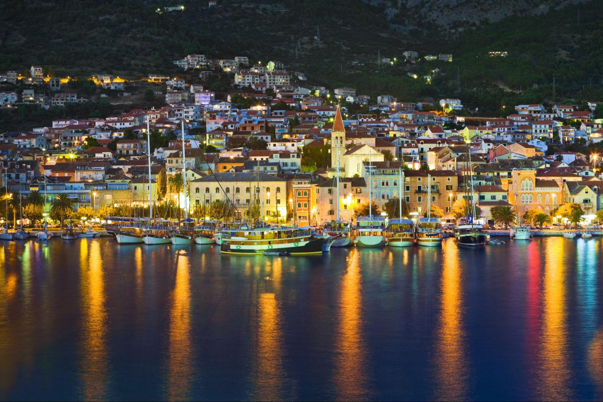 Night panorama of Makarska with a lit-up promenade and moored boats Night panorama of Makarska with a lit-up promenade and moored boats
