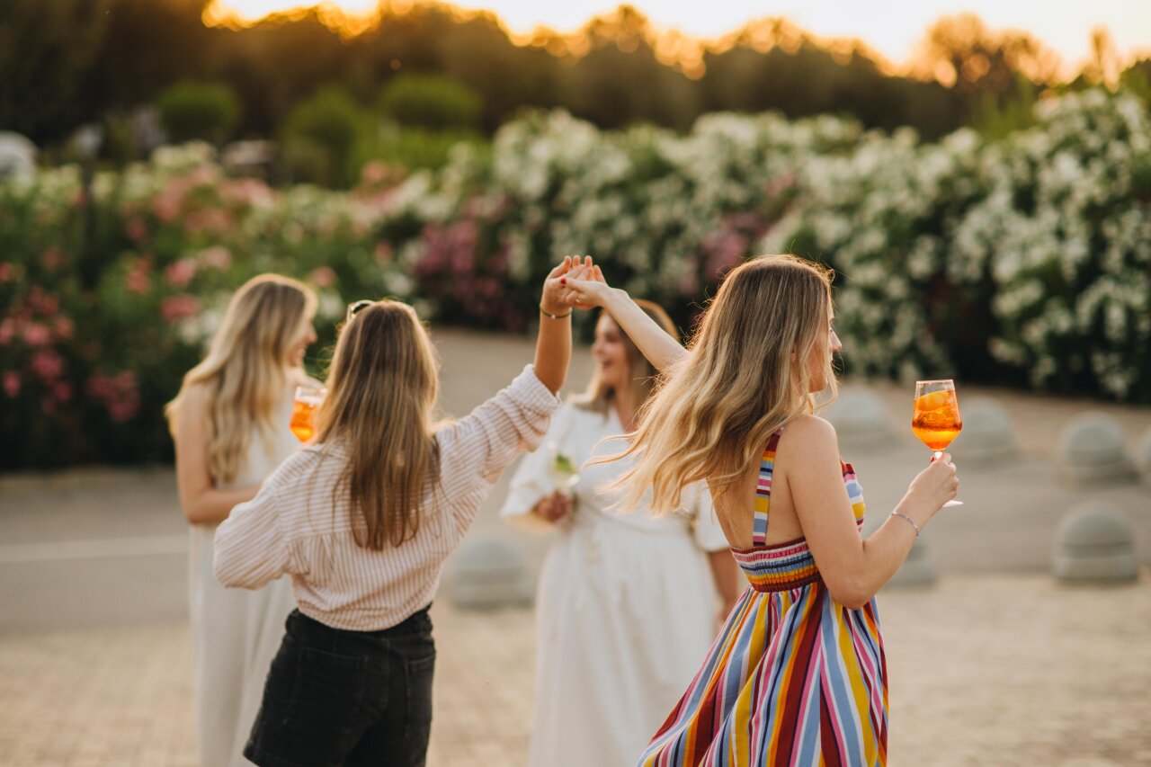 Women dancing and toasting cocktails at sunset in Istria Women dancing and toasting cocktails at sunset in Istria