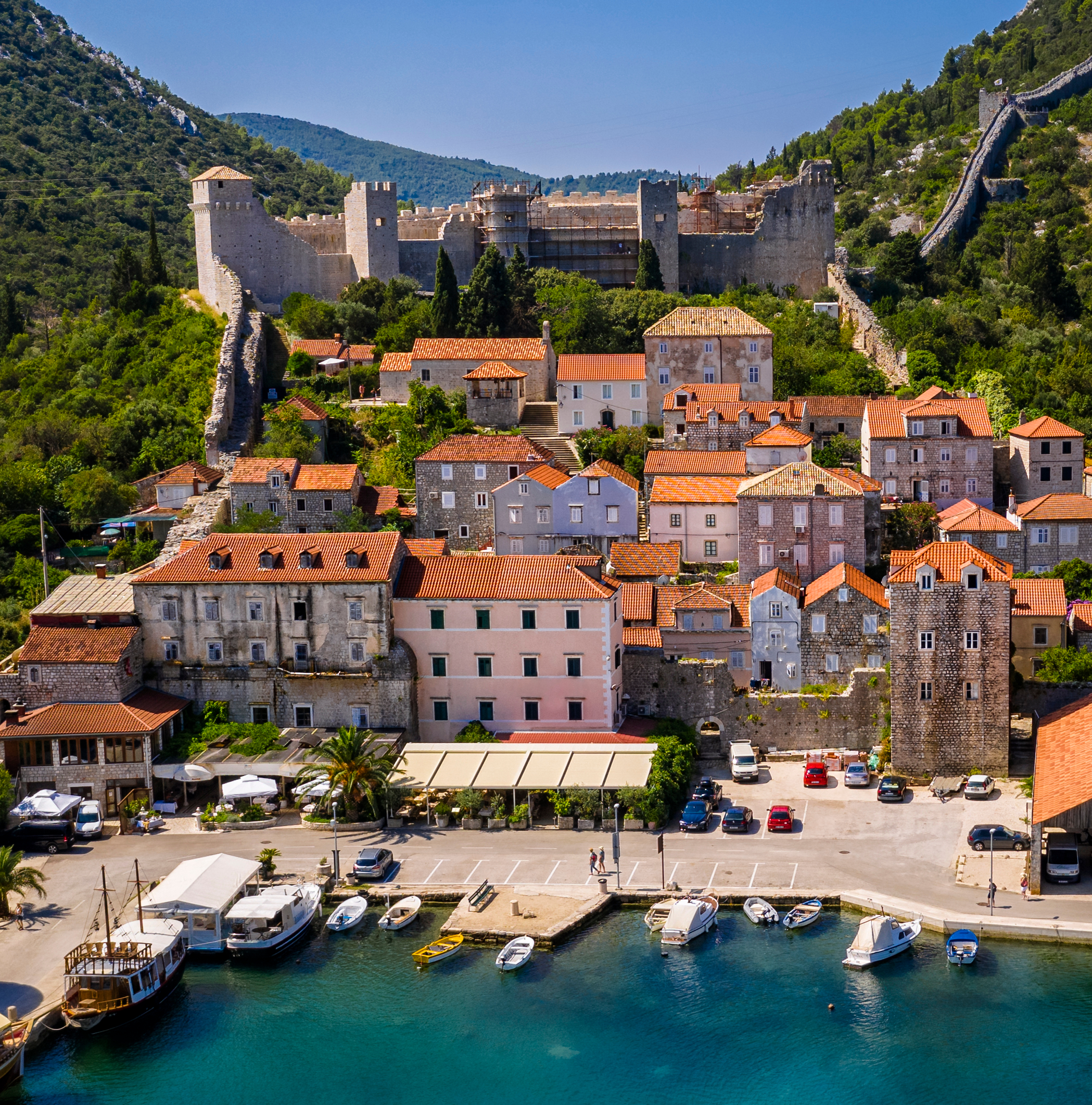 Aerial view of the historic town of Ston, Croatia, with medieval stone walls, terracotta-roofed houses, and a waterfront lined with boats Aerial view of the historic town of Ston, Croatia, with medieval stone walls, terracotta-roofed houses, and a waterfront lined with boats
