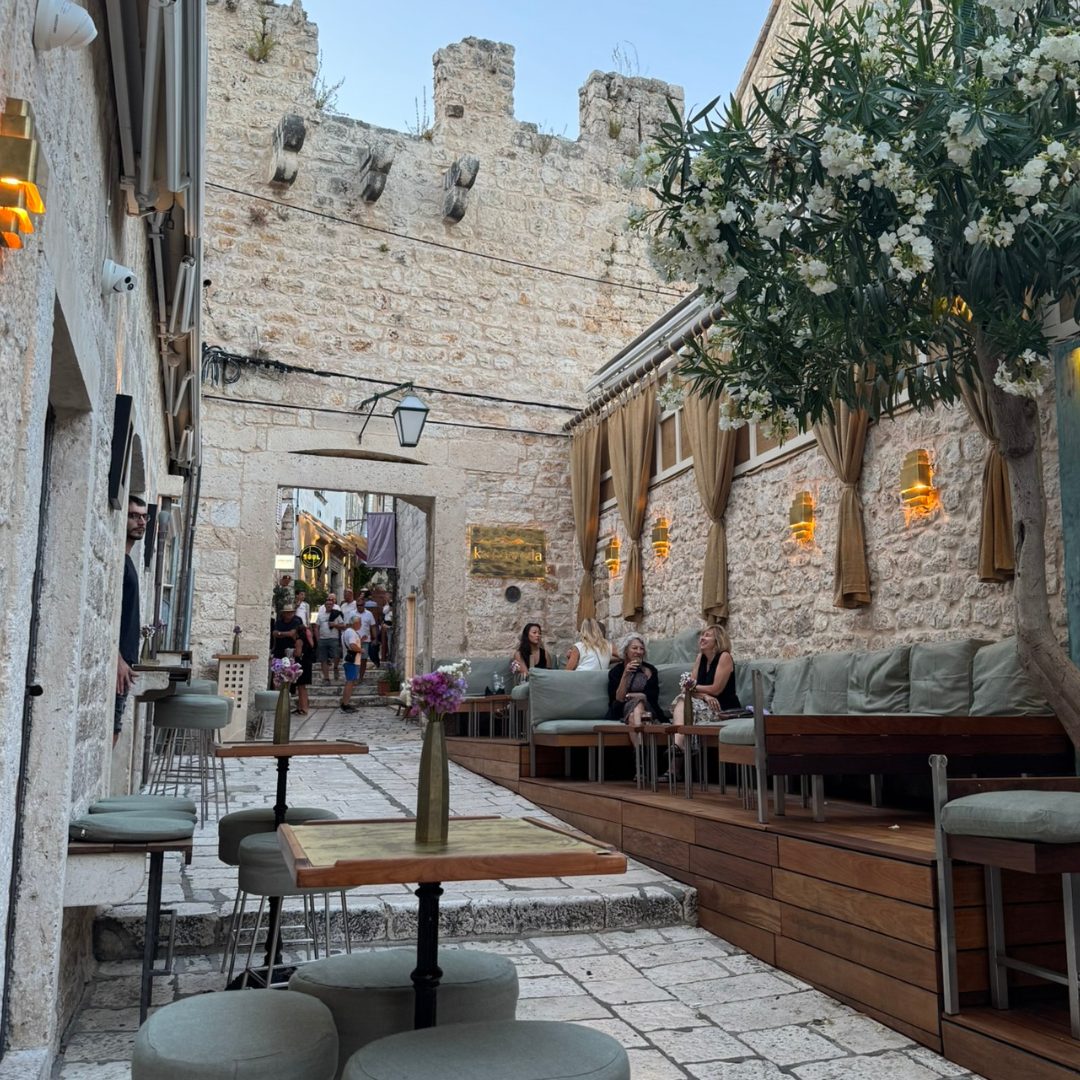 Outdoor lounge seating along Hvar&rsquo;s old stone streets with cosy sofas, tables, and historic walls in the background.