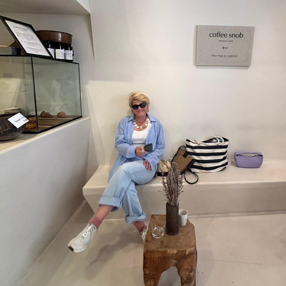 Woman relaxing with a coffee inside Coffee Snob in Hvar, a minimalist speciality caf&eacute;.