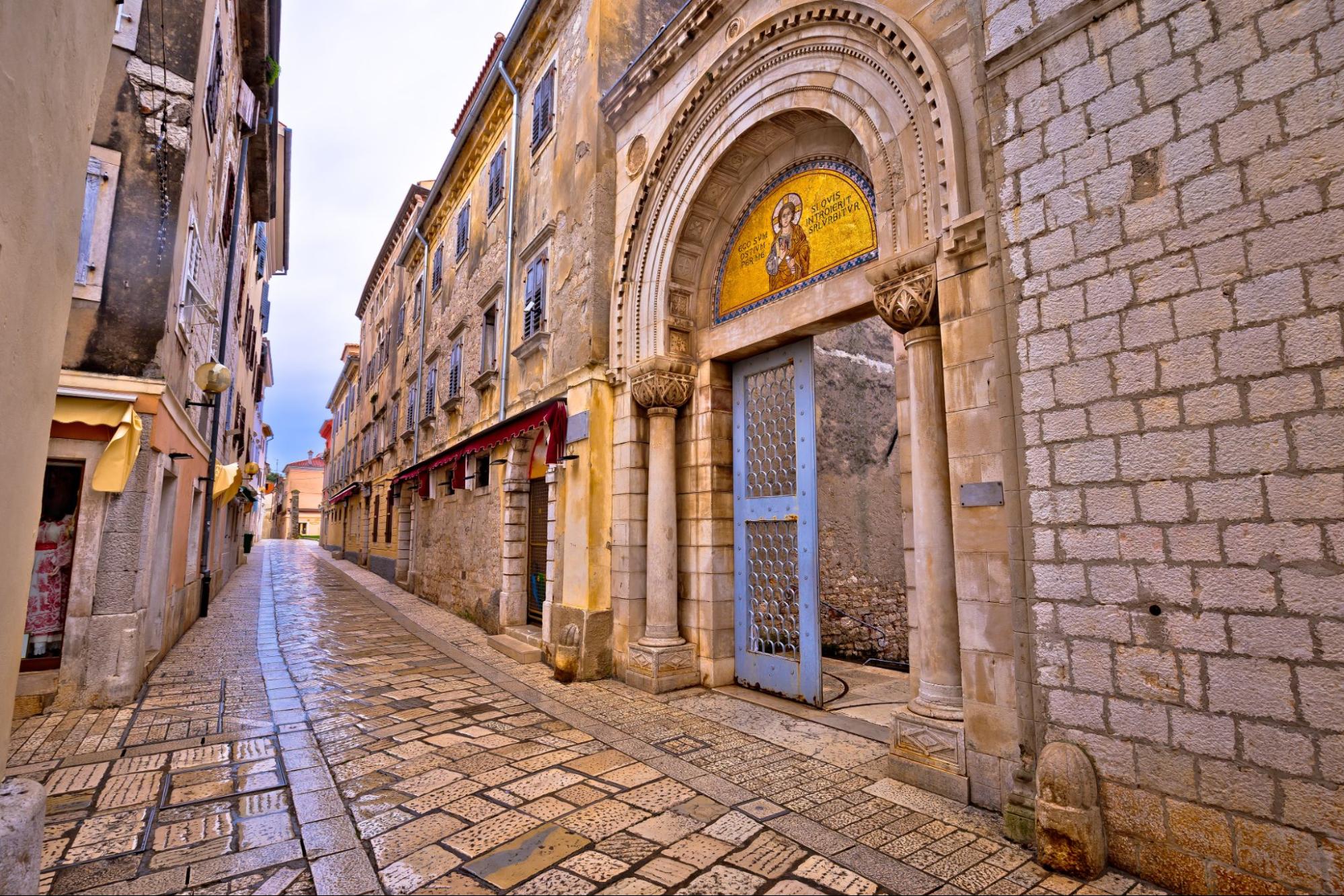 Eingang in eine alte Kirche mit Mosaiken und Steingasen in der Altstadt von Poreč Eingang in eine alte Kirche mit Mosaiken und Steingasen in der Altstadt von Poreč