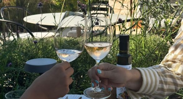 Toasting with glasses of wine over a table set with Istrian delicacies at Radovan Wines terrace.