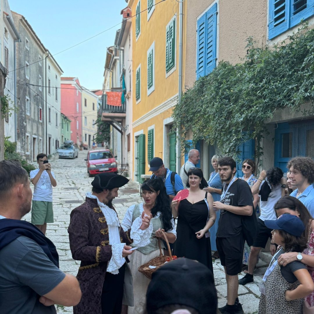 Narrow streets of Vrsar turn into an open-air stage for Casanova’s adventures Actors and audience interacting on a colourful cobbled street in Vrsar during the Casanova Tour.