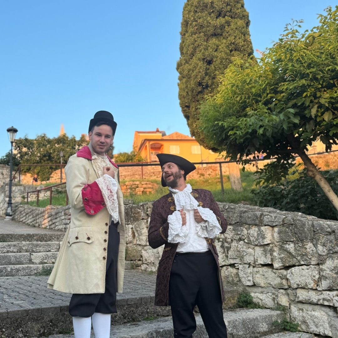 Witty exchanges and theatrical flair light up the stone streets of Vrsar Two male actors in historical costumes performing a comic scene on the stone steps of Vrsar.