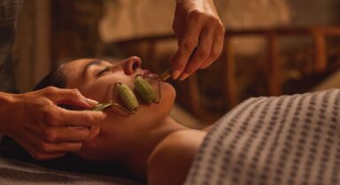 Eine Frau genie&szlig;t eine Gesichtsbehandlung mit einem Jaderoller.