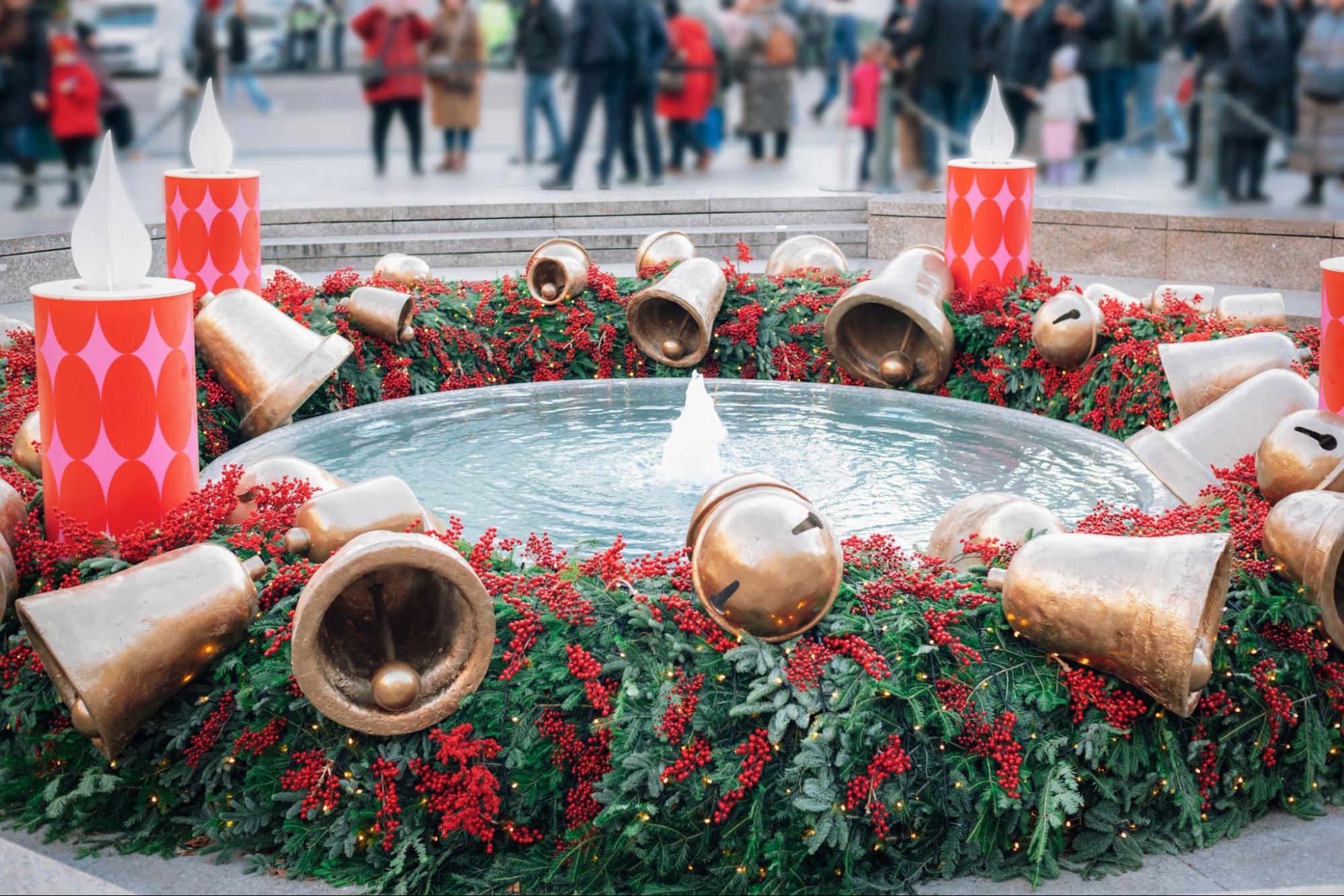 Ein runder Brunnen in Zagreb ist zum Advent prachtvoll dekoriert mit übergroßen goldenen Glocken, roten Beeren, immergrünen Zweigen und hohen, rot-rosa Stumpenkerzen. Ein runder Brunnen in Zagreb ist zum Advent prachtvoll dekoriert mit übergroßen goldenen Glocken, roten Beeren, immergrünen Zweigen und hohen, rot-rosa Stumpenkerzen.