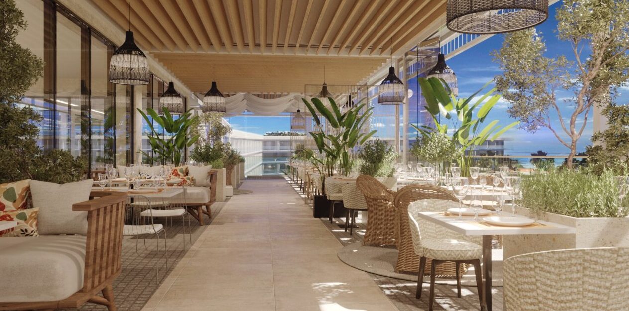 Open-Air-Restaurantterrasse im Pical mit Korbsesseln, Pendelleuchten, &uuml;ppigem Gr&uuml;n und Meerblick. 