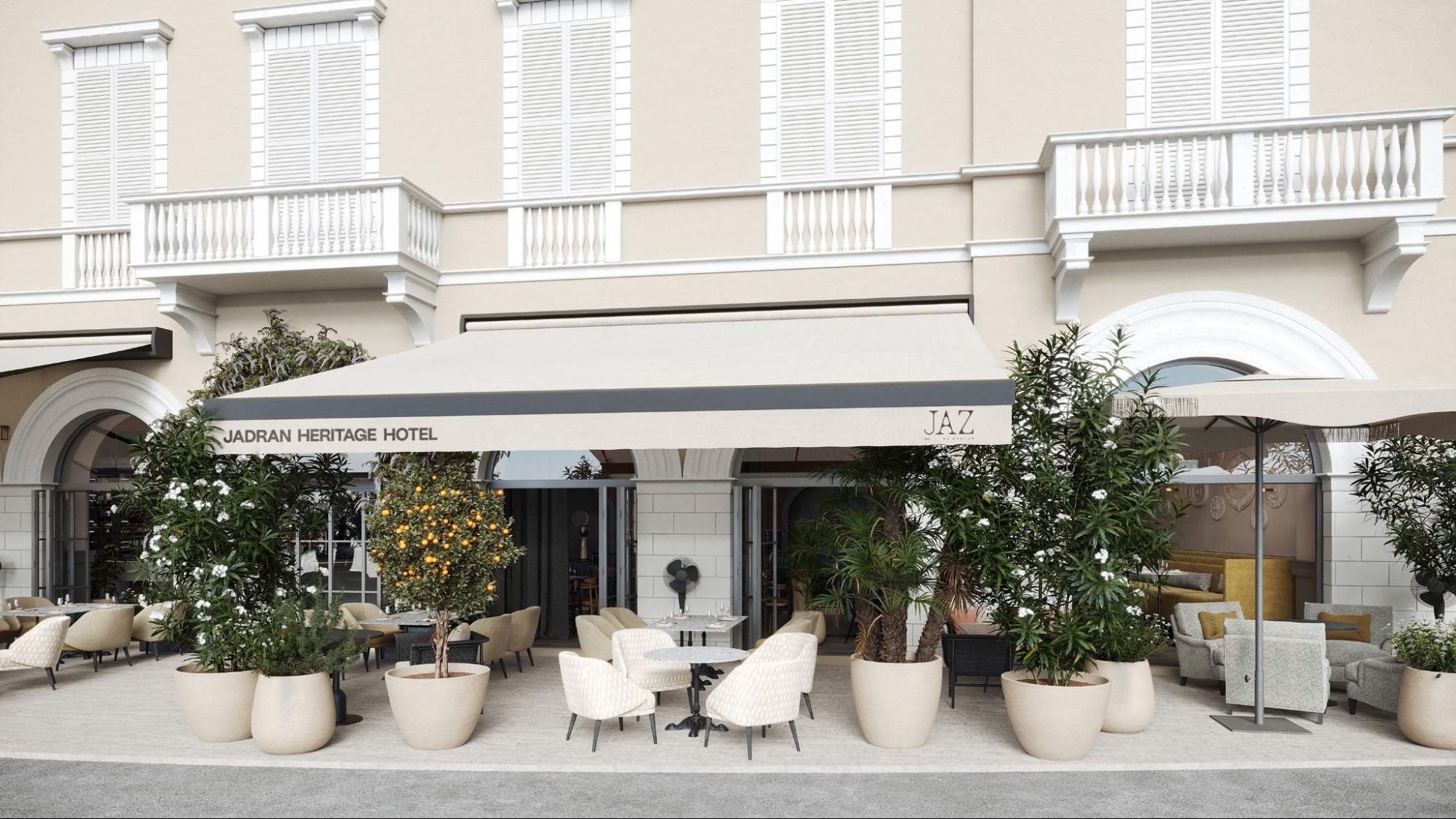 Elegant hotel fa&ccedil;ade and a stylish street-level terrace filled with lush potted plants and outdoor seating at JAZ by Ana Ro&scaron;. 