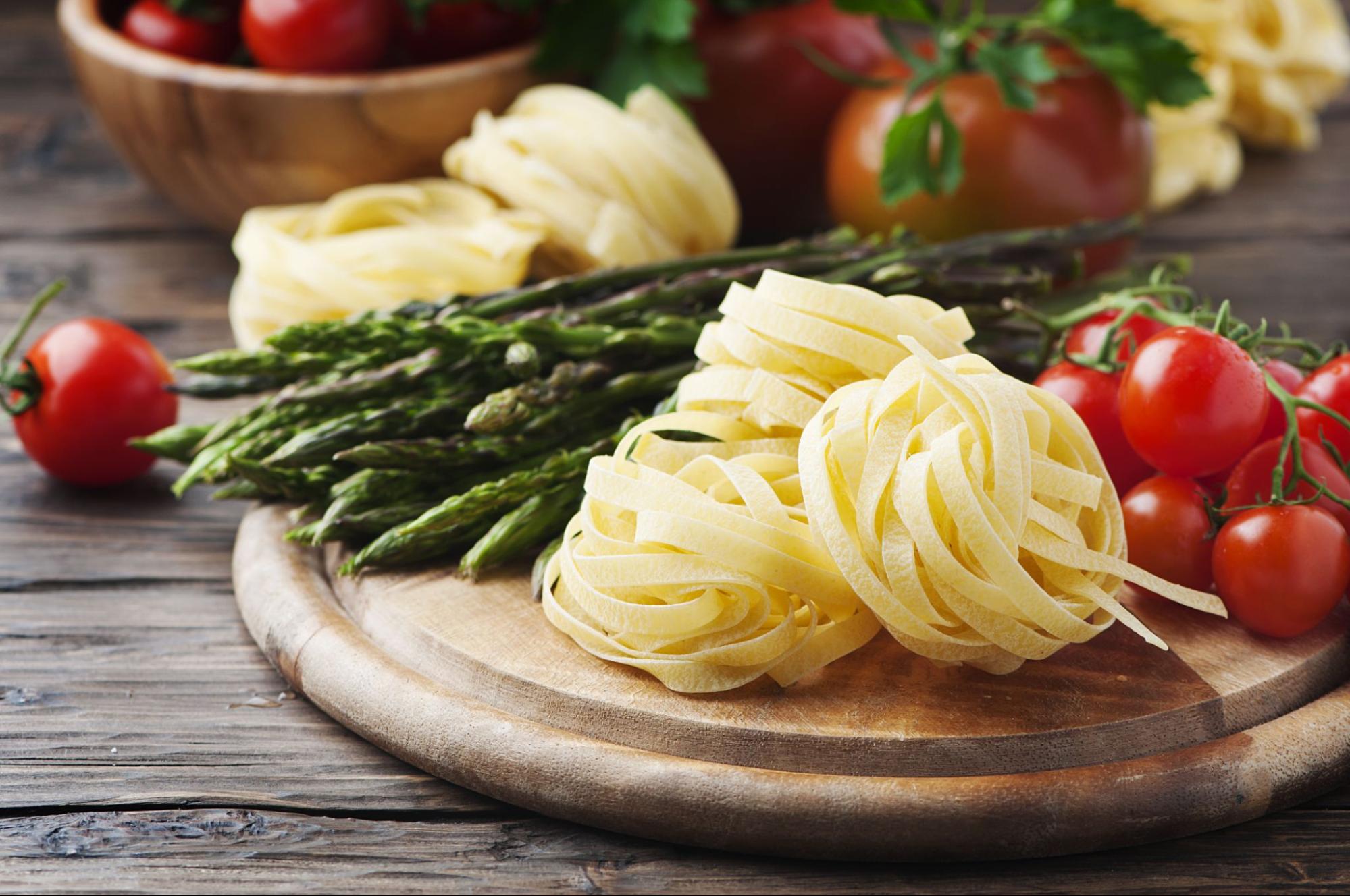 Frischer Spargel und handgemachte Nudeln auf einem Holzbrett, eine saisonale Fr&uuml;hlingsspeise in Istrien.