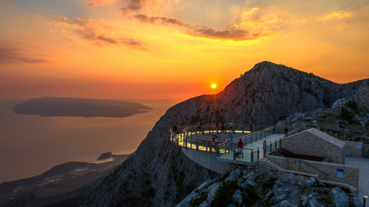 A glass observation platform extending from the rocky cliffs of Biokovo Mountain above Makarska. Eine gläserne Aussichtsplattform an den Felshängen des Biokovo-Gebirges oberhalb von Makarska.