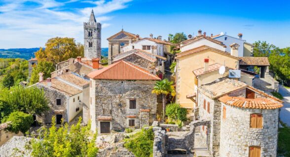 Panorama of Hum, the world’s smallest town, with stone houses and a church tower surrounded by greenery