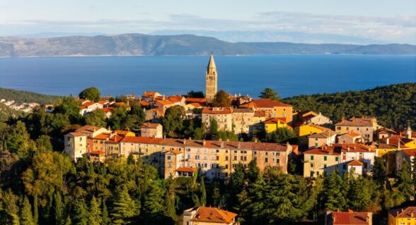 Panoramablick auf die Altstadt von Labin mit Terrakotta-Dächern und Blick auf die Adria und ferne Berge.