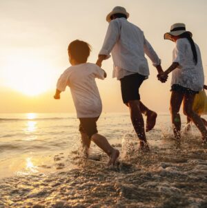 Family walking along the Adriatic shoreline at sunset during a summer holiday in Croatia