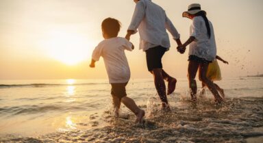 Family walking along the Adriatic shoreline at sunset during a summer holiday in Croatia