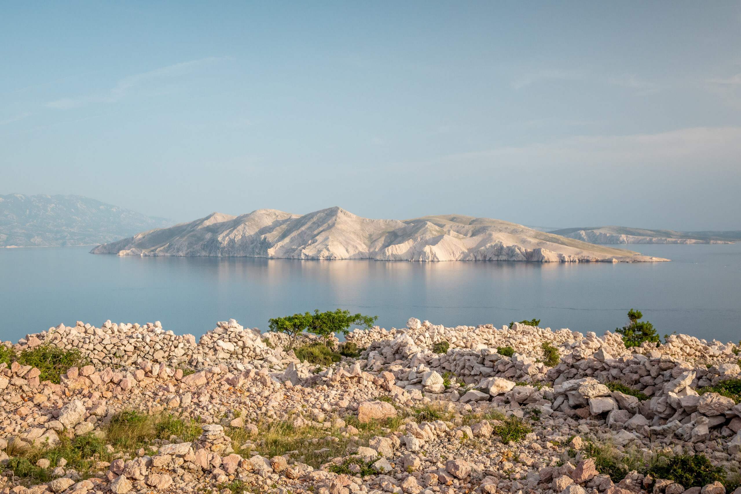 View of Krk Island&rsquo;s rocky landscape and calm sea in soft spring light