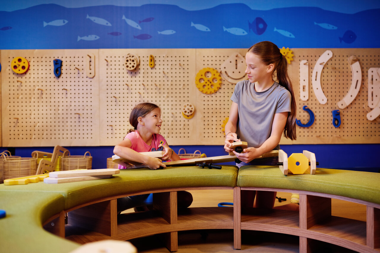 Two children taking part in a creative workshop and assembling wooden toys in the kids&rsquo; club at Arba Resort on Rab.
