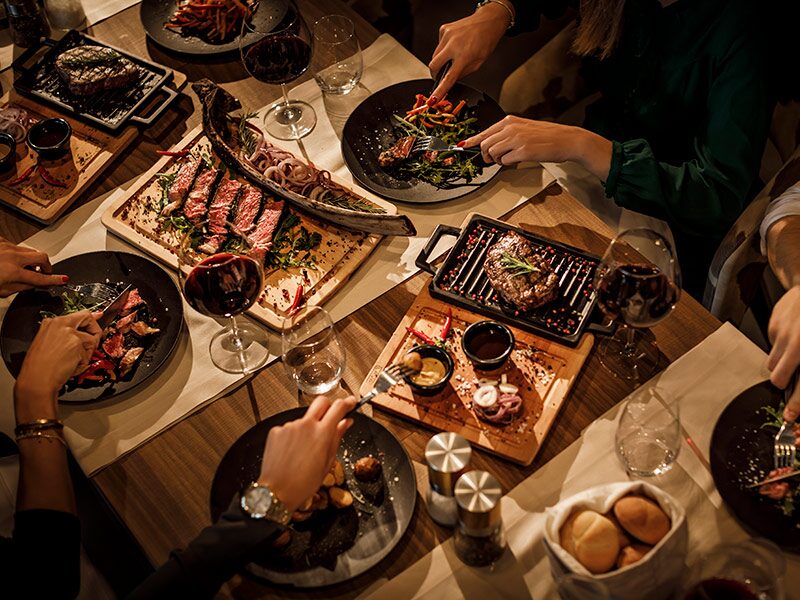 Guests enjoying a steak dinner in a restaurant, capturing an authentic dining experience at Black & Blue Steakhouse